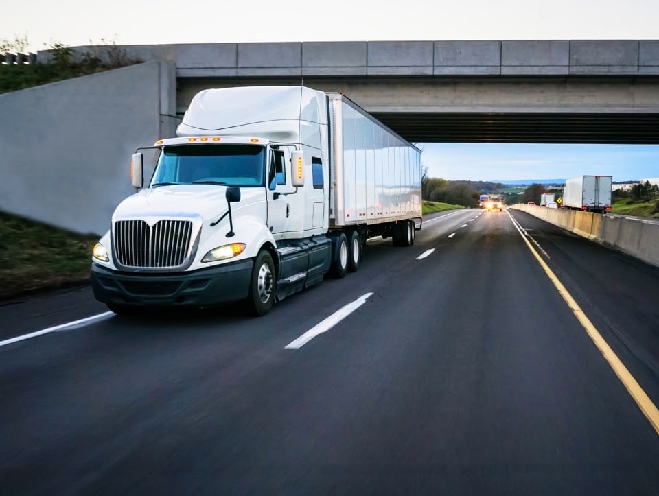 SCRM Integrates with DAT Freight and Analytics - A truck moving on highway